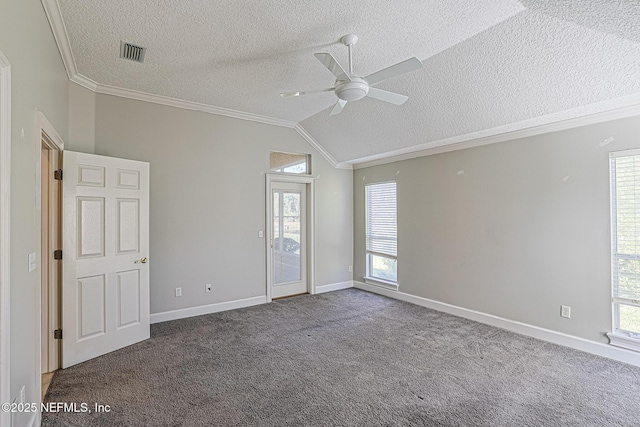 carpeted empty room featuring ceiling fan, crown molding, vaulted ceiling, and a textured ceiling