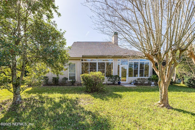 rear view of house featuring a lawn