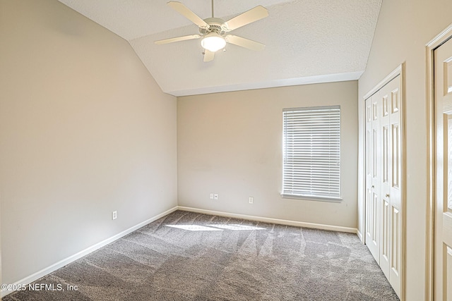 unfurnished bedroom with lofted ceiling, carpet flooring, a textured ceiling, and ceiling fan