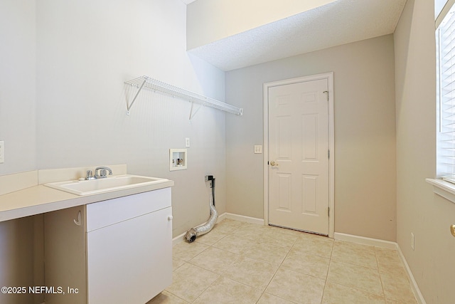 laundry area featuring sink, cabinets, washer hookup, light tile patterned floors, and a textured ceiling