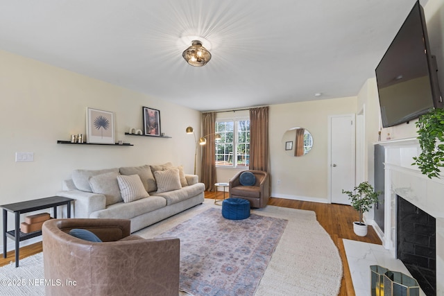 living room with a premium fireplace and light wood-type flooring