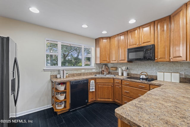 kitchen with dark hardwood / wood-style flooring, sink, backsplash, and black appliances