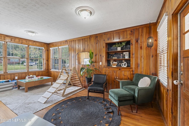 interior space with hardwood / wood-style floors, a textured ceiling, and wood walls