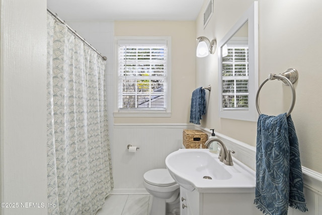 bathroom with vanity, tile patterned flooring, toilet, and walk in shower