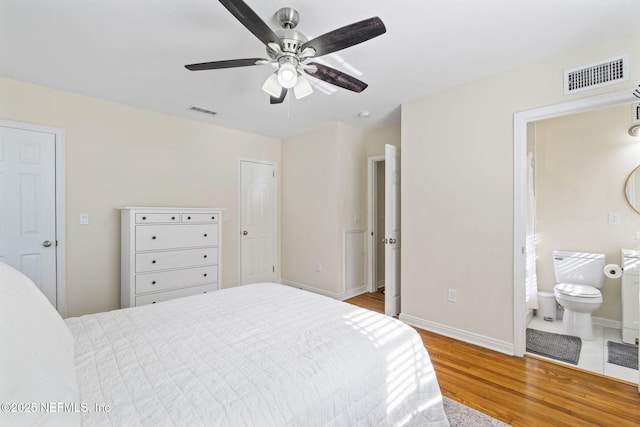 bedroom with hardwood / wood-style flooring, ceiling fan, and ensuite bath