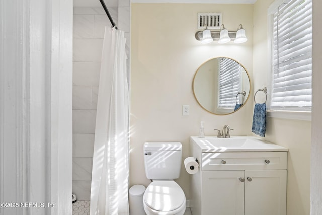 bathroom featuring vanity, curtained shower, and toilet