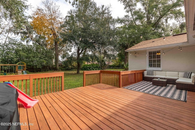 wooden deck with an outdoor hangout area, a playground, and a lawn