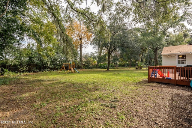 view of yard featuring a wooden deck and a playground