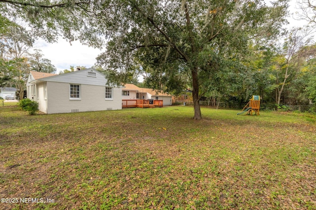 view of yard with a playground and a deck