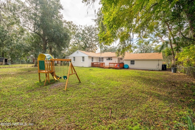 view of yard with a wooden deck and a playground