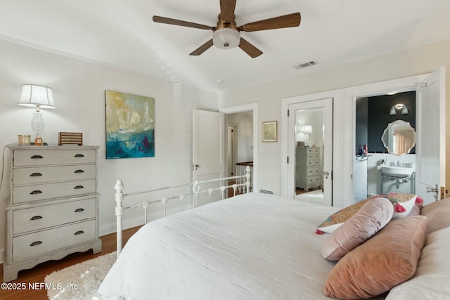 bedroom with connected bathroom, dark wood-type flooring, sink, and ceiling fan