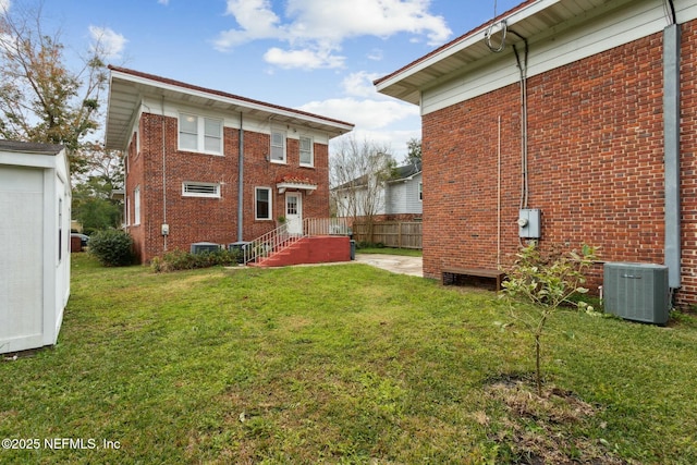 back of house featuring central AC and a lawn