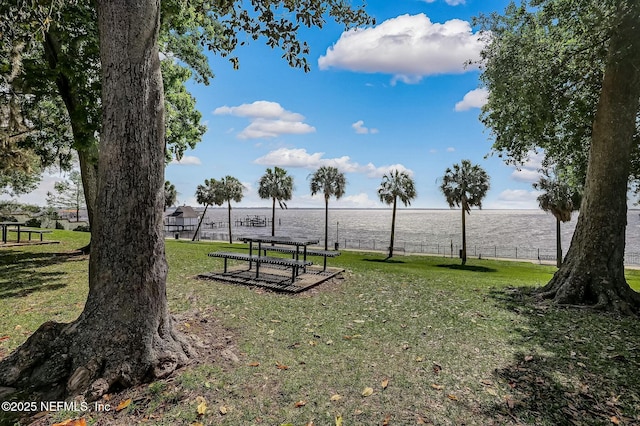 view of home's community featuring a water view and a lawn