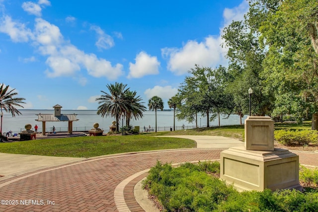 surrounding community featuring a water view and a yard