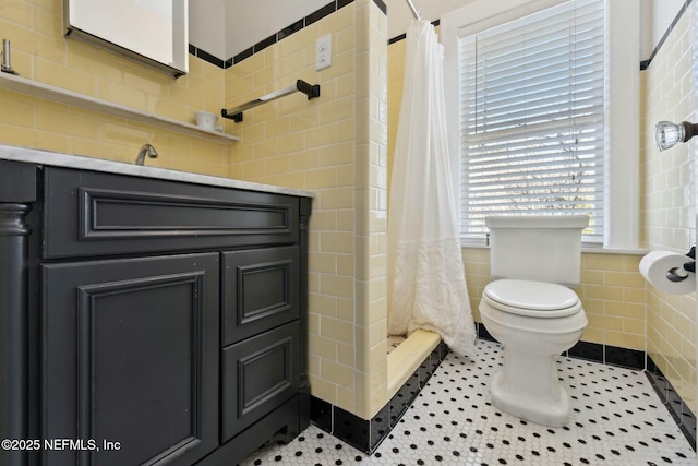 bathroom with tile patterned flooring, toilet, tile walls, and a shower with curtain