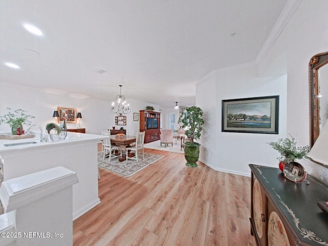 interior space featuring sink, ornamental molding, a chandelier, and light wood-type flooring