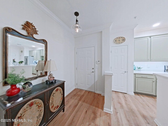 foyer featuring ornamental molding and light wood-type flooring