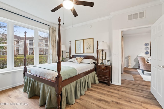 bedroom with crown molding, ceiling fan, and light hardwood / wood-style floors