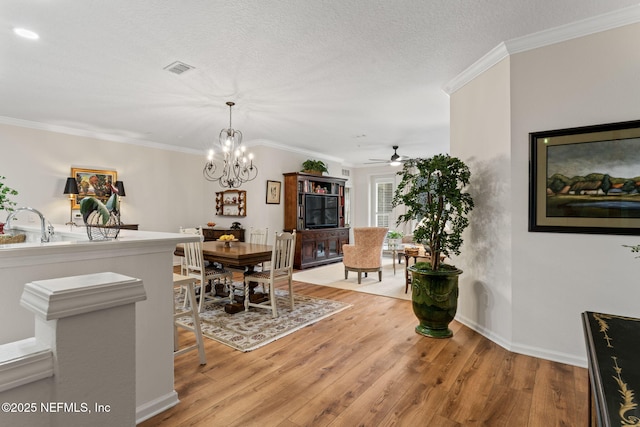 dining area featuring crown molding, light hardwood / wood-style floors, and a textured ceiling