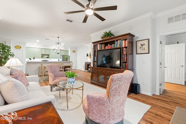 living room featuring ornamental molding, ceiling fan with notable chandelier, and light hardwood / wood-style floors