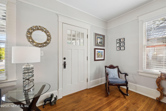 entryway with crown molding and dark wood-type flooring