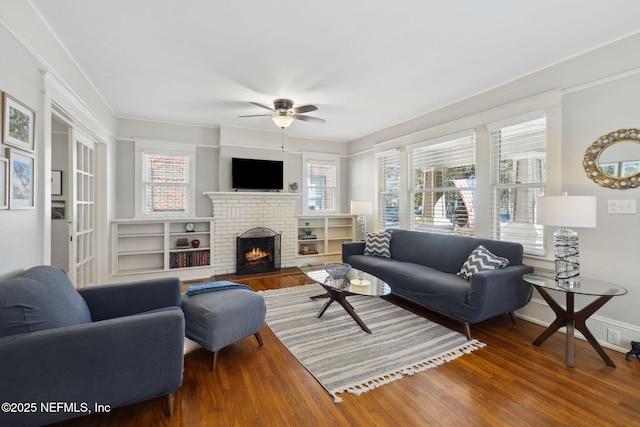 living room with ceiling fan, a fireplace, dark wood-type flooring, and plenty of natural light