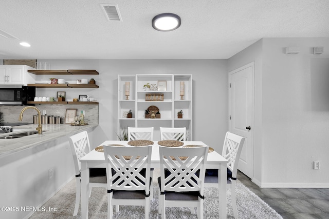 dining area with sink and a textured ceiling