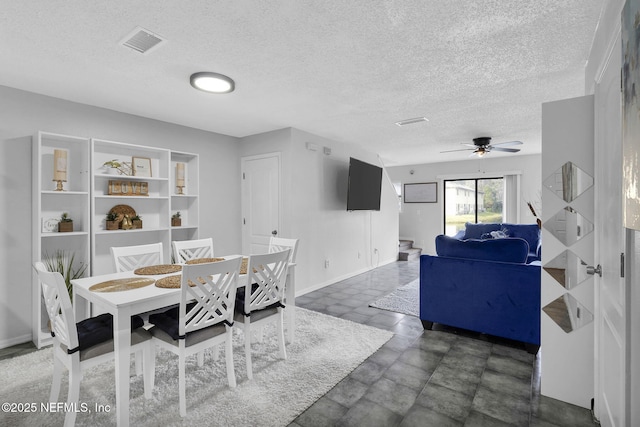 dining space featuring ceiling fan and a textured ceiling