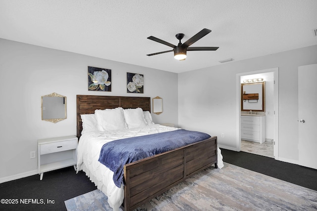 bedroom featuring ceiling fan, a textured ceiling, and ensuite bath