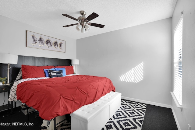 carpeted bedroom with ceiling fan and a textured ceiling