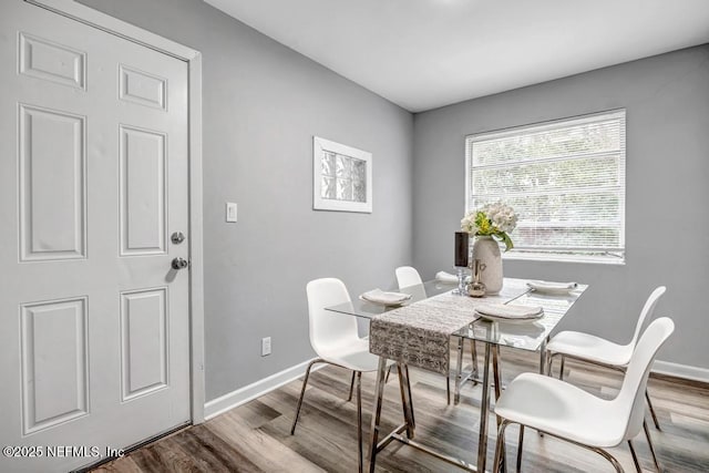 dining space with wood-type flooring