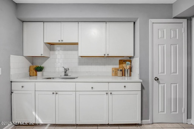 kitchen with white cabinets, decorative backsplash, and sink