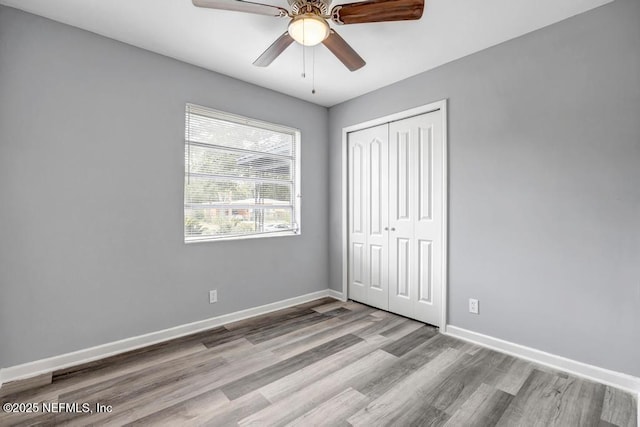 unfurnished bedroom featuring light hardwood / wood-style flooring, a closet, and ceiling fan