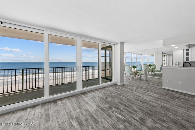 unfurnished sunroom with a water view and a sink