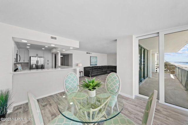 dining area featuring baseboards, light wood-style flooring, visible vents, and recessed lighting