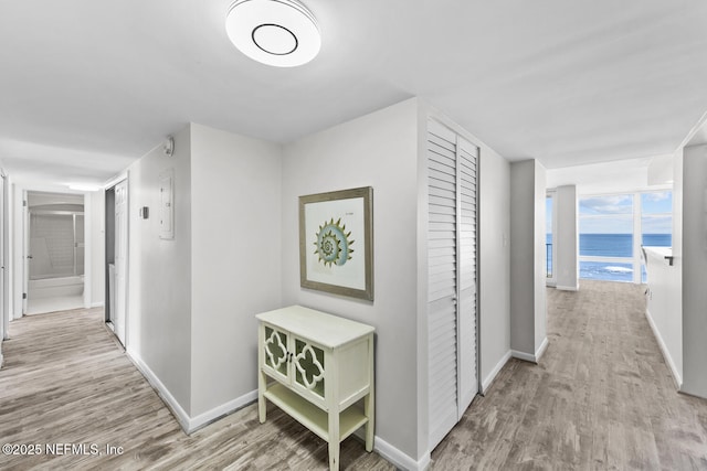 hall featuring wood finished floors and baseboards