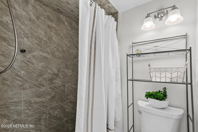 bathroom featuring toilet and tiled shower