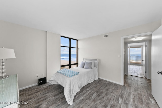 bedroom with baseboards, visible vents, and wood finished floors