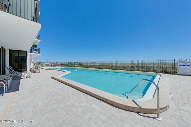 community pool featuring fence and a patio