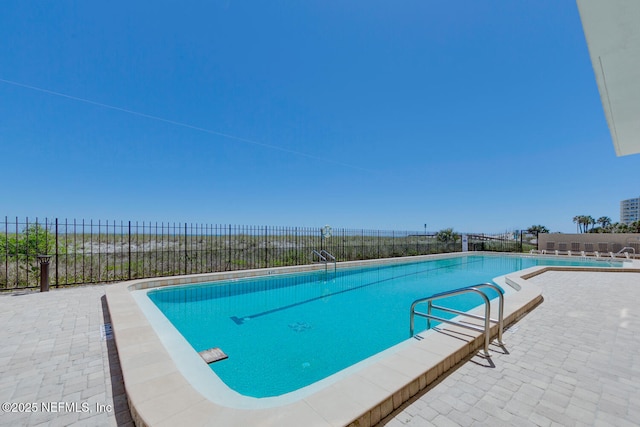 pool with a patio and fence