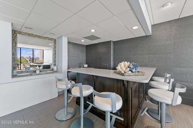 bar featuring a dry bar, a paneled ceiling, tile walls, and recessed lighting