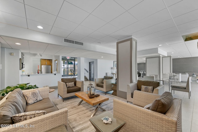 living room featuring a paneled ceiling, visible vents, and recessed lighting