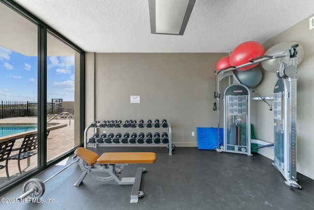 exercise room featuring visible vents, expansive windows, baseboards, and a textured ceiling