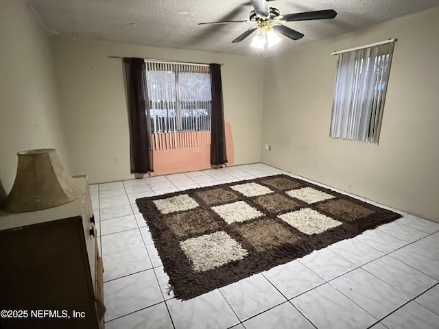 empty room with a textured ceiling and ceiling fan