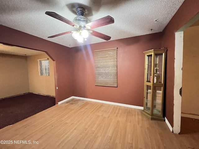 spare room featuring ceiling fan, hardwood / wood-style floors, and a textured ceiling