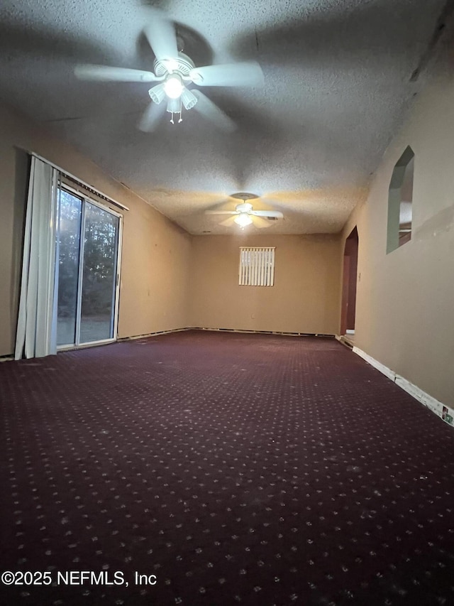 carpeted empty room with ceiling fan and a textured ceiling