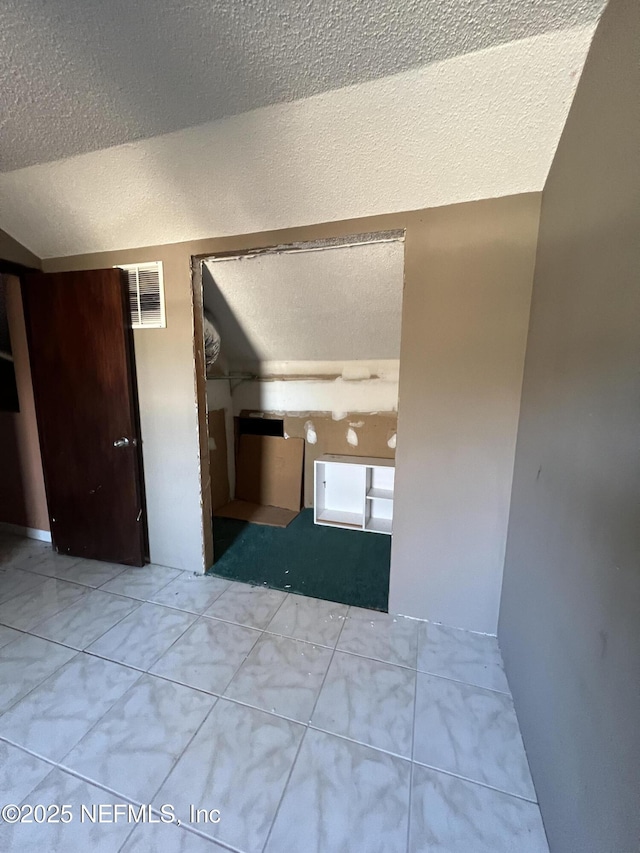 unfurnished room featuring tile patterned floors and a textured ceiling