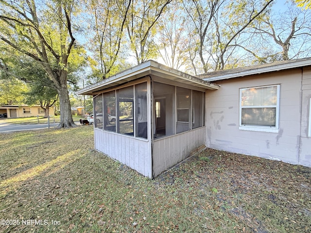 view of side of property with a sunroom and a yard