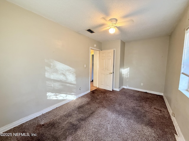 unfurnished bedroom with ceiling fan, dark carpet, and a textured ceiling