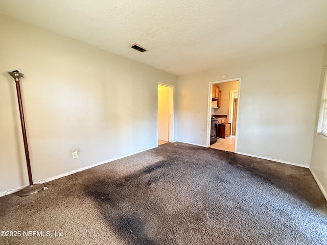 carpeted empty room with a textured ceiling